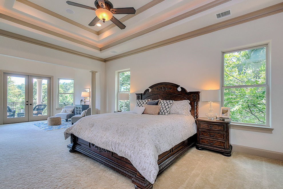Photo of an expansive mediterranean master bedroom in Houston with beige walls, carpet, no fireplace and brown floor.