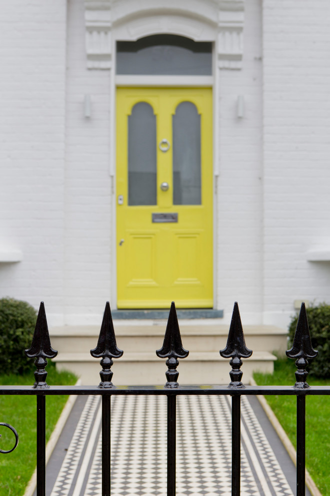 Photo of a large contemporary front door in London with white walls, a single front door and a yellow front door.