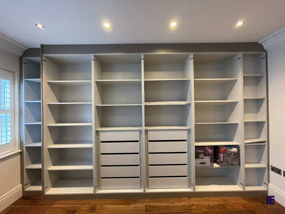 Photo of a small modern built-in wardrobe in London with glass-front cabinets, grey cabinets, plywood flooring, brown floors, a wood ceiling and feature lighting.