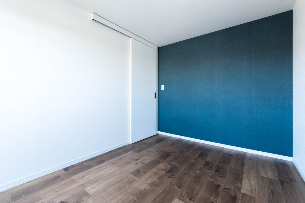 Design ideas for a mid-sized arts and crafts master bedroom in Tokyo with blue walls, no fireplace and brown floor.
