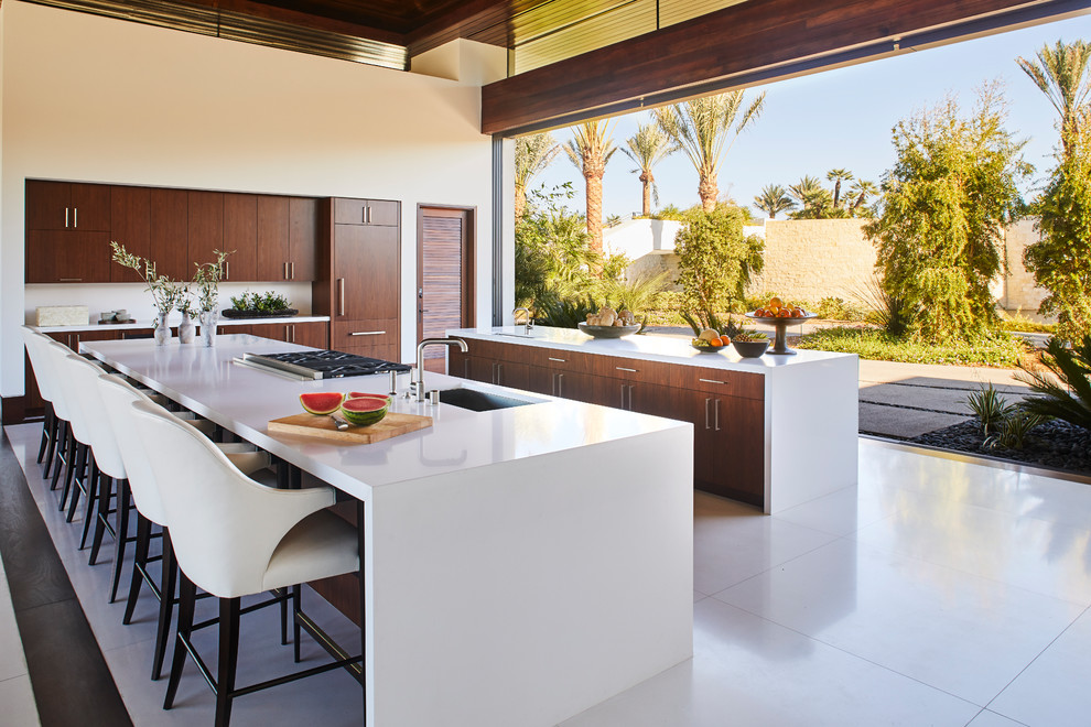 Open concept kitchen - large modern white floor open concept kitchen idea with an undermount sink, flat-panel cabinets, dark wood cabinets, quartz countertops, stainless steel appliances, two islands and white countertops