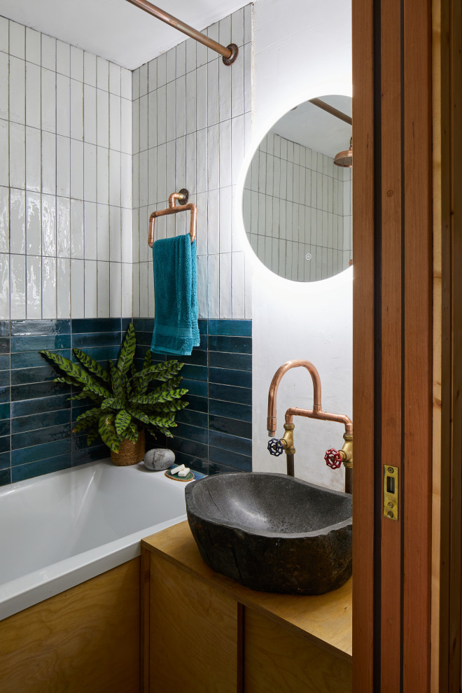 Cette image montre une petite salle de bain design avec une baignoire posée, un carrelage blanc, des carreaux de céramique et un mur blanc.