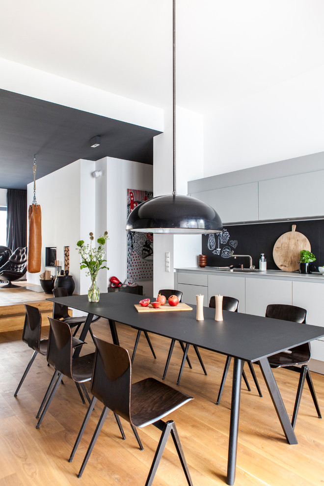 Design ideas for a mid-sized scandinavian kitchen/dining combo in Berlin with white walls and medium hardwood floors.