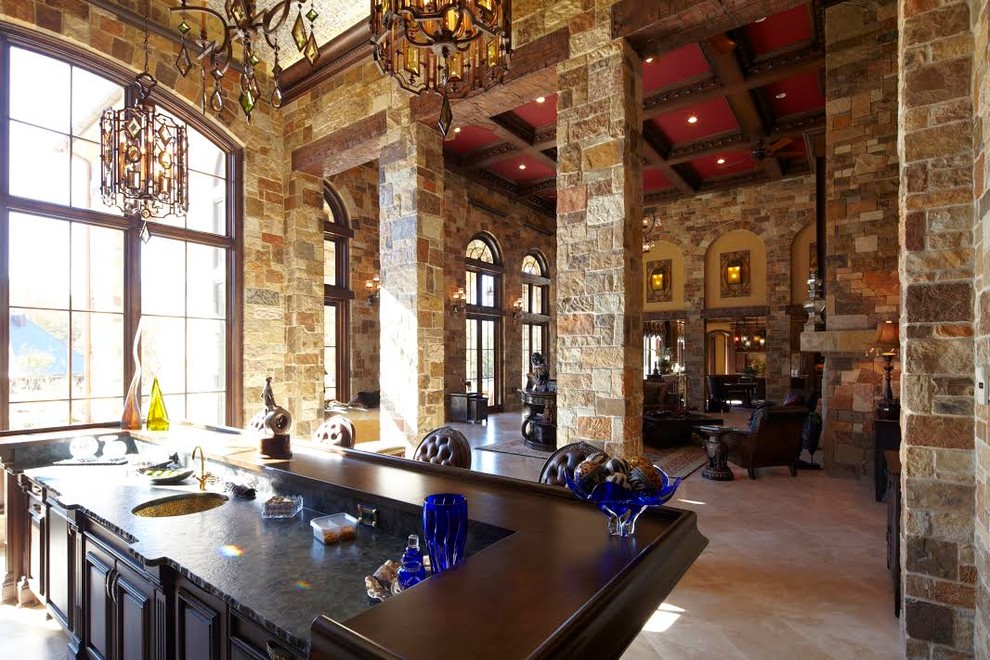 Enclosed kitchen - mid-sized rustic limestone floor enclosed kitchen idea in Austin with an undermount sink, recessed-panel cabinets, dark wood cabinets and an island