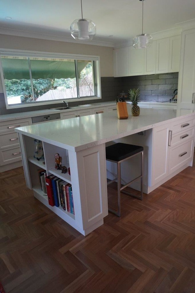 Inspiration for a large contemporary u-shaped kitchen in Sydney with a drop-in sink, shaker cabinets, white cabinets, quartz benchtops, grey splashback, subway tile splashback, stainless steel appliances, medium hardwood floors and with island.