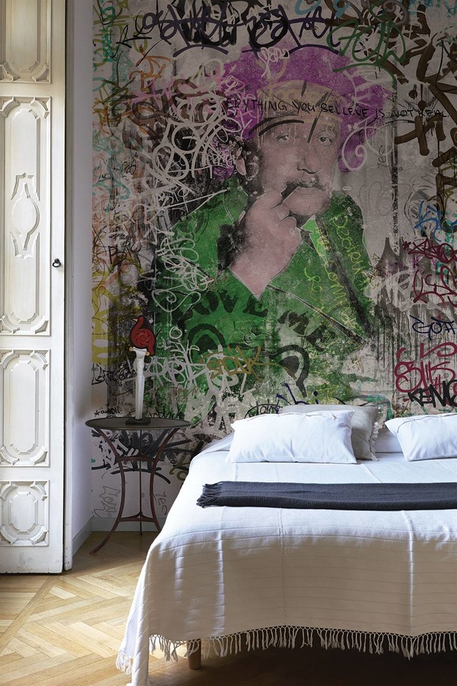 Inspiration for a mid-sized industrial master bedroom in Venice with multi-coloured walls and light hardwood floors.