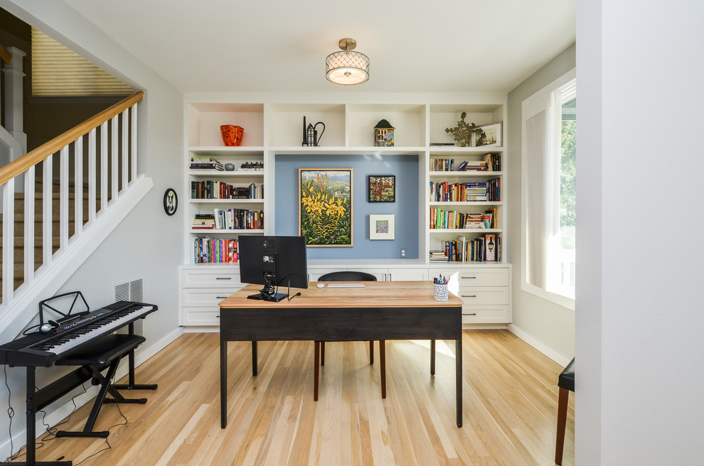 Transitional home office in Seattle with grey walls, light hardwood floors, a freestanding desk and beige floor.