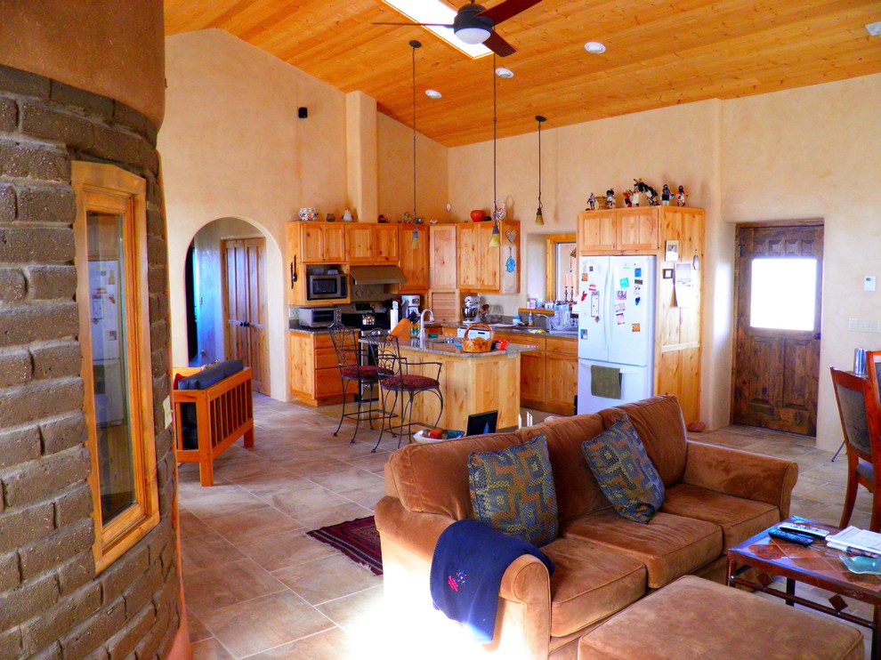 Large open concept living room in Albuquerque with beige walls, travertine floors and a wood stove.