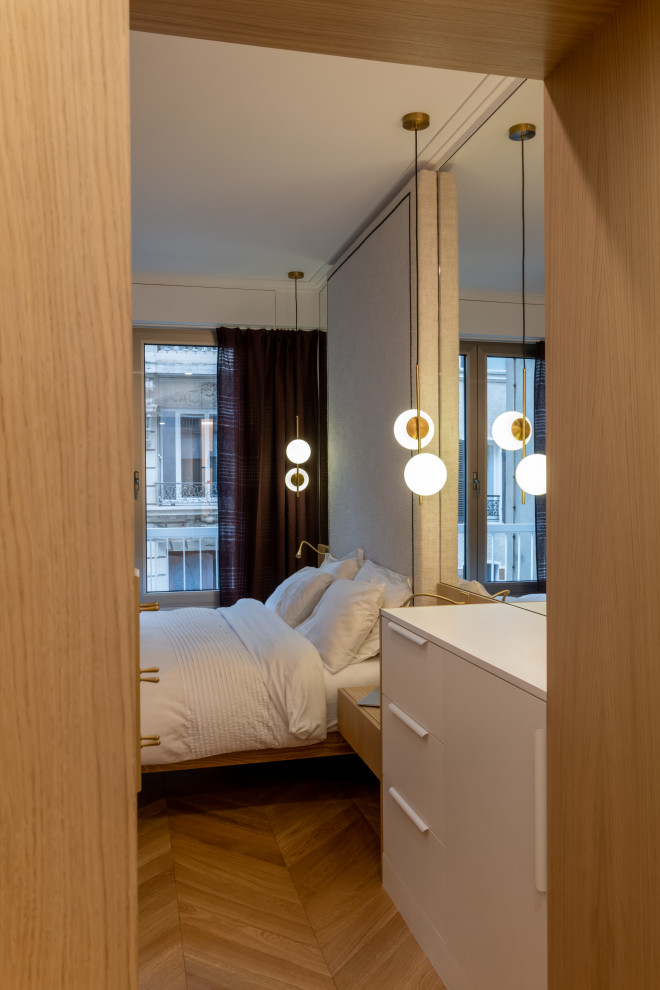 Ejemplo de dormitorio principal y blanco y madera contemporáneo de tamaño medio con paredes blancas, suelo de madera clara, suelo marrón y papel pintado