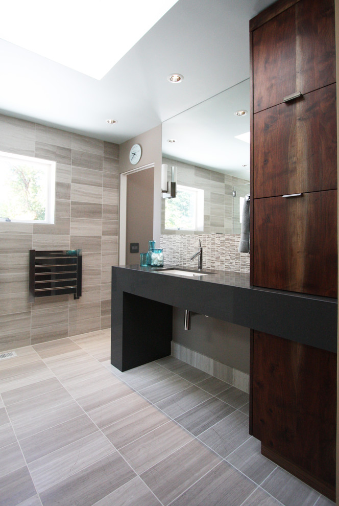 Inspiration for a large contemporary master black tile limestone floor alcove shower remodel in Portland with flat-panel cabinets, dark wood cabinets, a one-piece toilet, beige walls, an undermount sink and quartz countertops