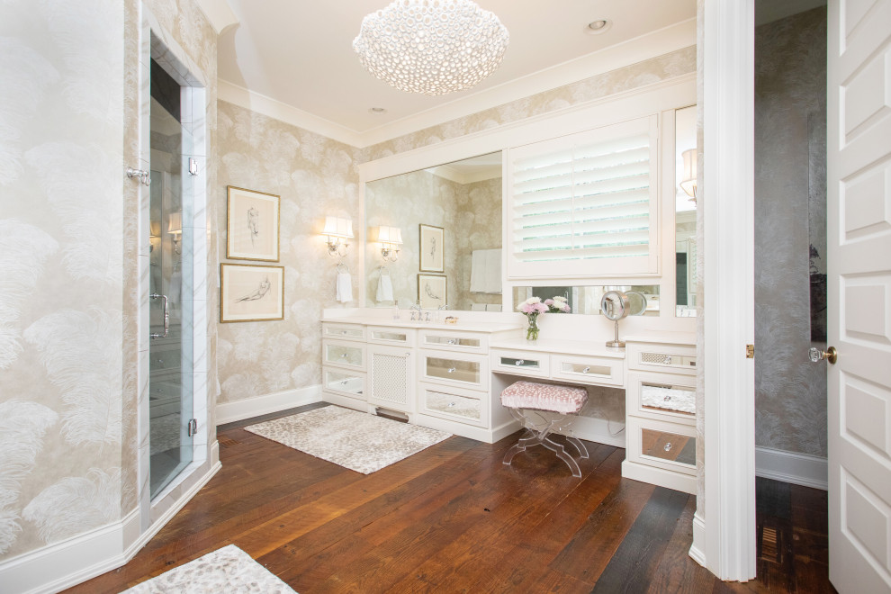 Photo of a traditional master bathroom in Other with glass-front cabinets, white cabinets, a corner shower, dark hardwood floors, a hinged shower door, white benchtops, an enclosed toilet, a double vanity, a built-in vanity and wallpaper.