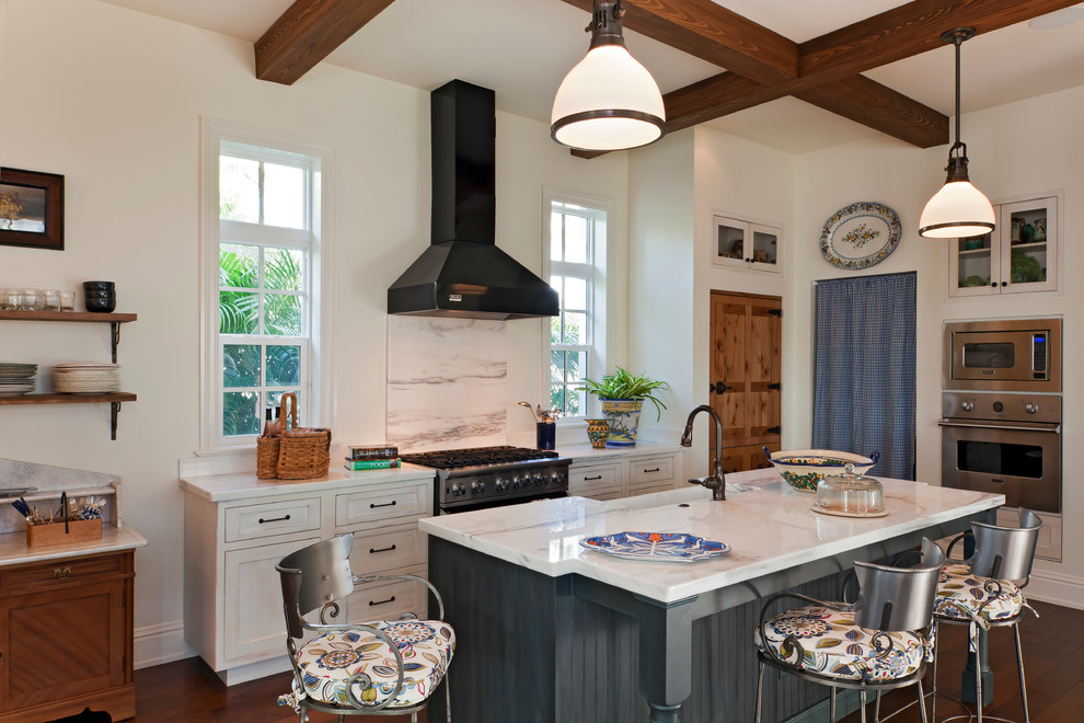 Inspiration for a country galley eat-in kitchen in Miami with a farmhouse sink, recessed-panel cabinets, white cabinets, white splashback, stainless steel appliances, quartzite benchtops, stone slab splashback, dark hardwood floors and with island.