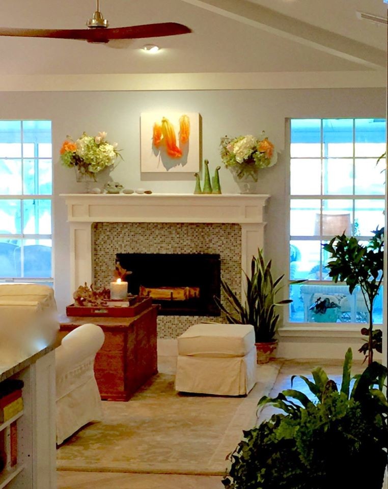 This is an example of a mid-sized beach style open concept living room in Jacksonville with blue walls, a standard fireplace, a wood fireplace surround, porcelain floors, no tv and brown floor.