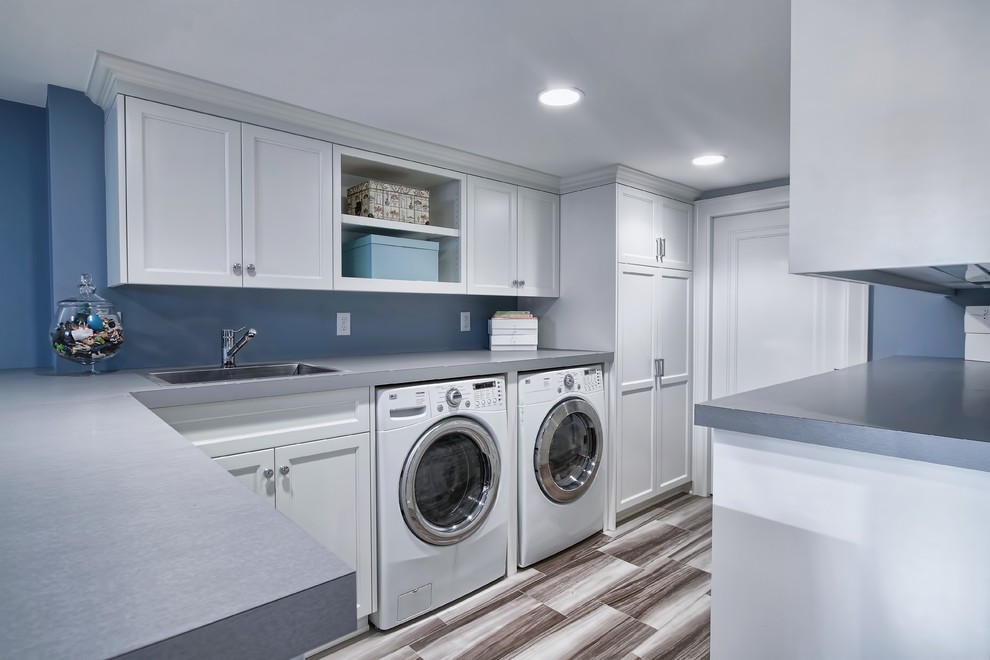 Mid-sized traditional laundry room in Minneapolis with a drop-in sink, white cabinets, laminate benchtops, blue walls, ceramic floors, a side-by-side washer and dryer and recessed-panel cabinets.