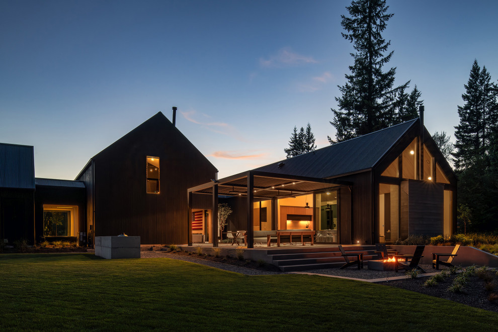 Свежая идея для дизайна: двухэтажный, деревянный, черный частный загородный дом среднего размера в скандинавском стиле с двускатной крышей, металлической крышей и черной крышей - отличное фото интерьера