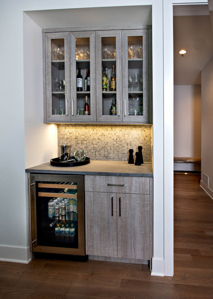 This is an example of a country home bar in Chicago with flat-panel cabinets, grey cabinets, concrete benchtops, grey splashback, ceramic splashback and grey benchtop.
