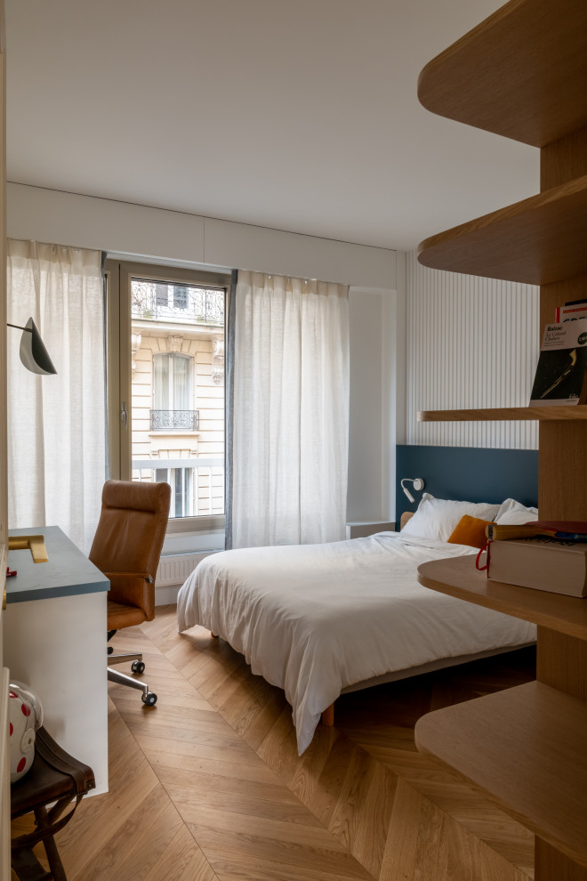 Photo of a large contemporary kids' room for boys in Paris with white walls, light hardwood floors, brown floor and decorative wall panelling.