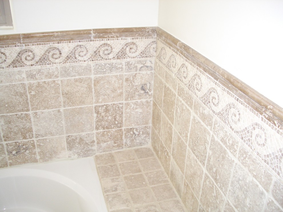 Photo of a mid-sized mediterranean master bathroom in Los Angeles with furniture-like cabinets, brown cabinets, a freestanding tub, an alcove shower, a one-piece toilet, beige tile, travertine, beige walls, travertine floors, a drop-in sink, engineered quartz benchtops, multi-coloured floor, a hinged shower door and brown benchtops.