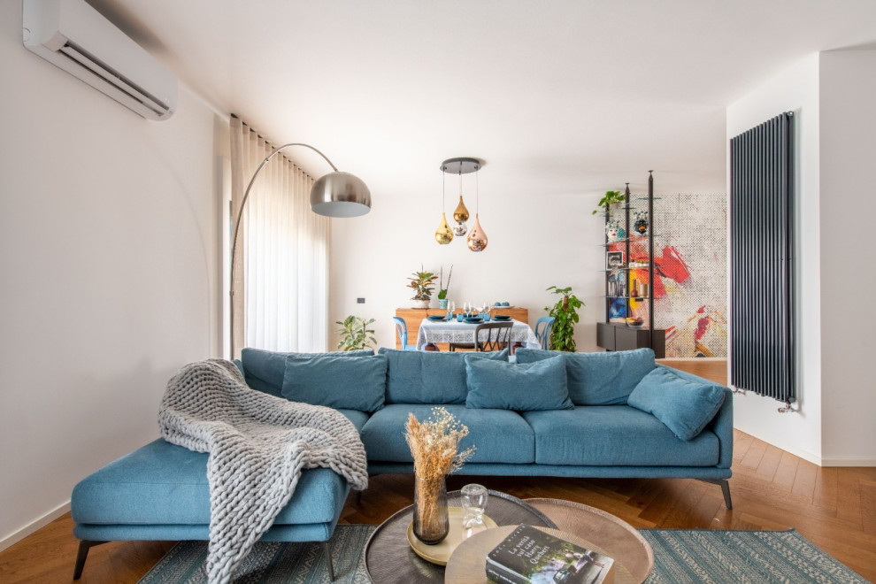This is an example of a mid-sized eclectic formal open concept living room in Catania-Palermo with white walls, light hardwood floors and a built-in media wall.