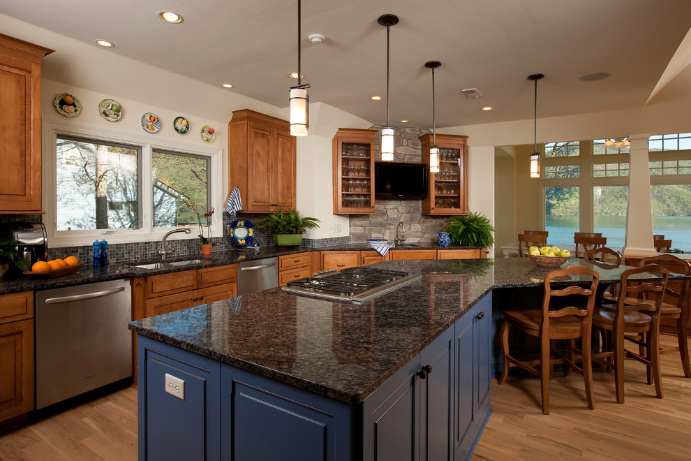 Inspiration for a mid-sized transitional galley light wood floor eat-in kitchen remodel with a double-bowl sink, raised-panel cabinets, medium tone wood cabinets, granite countertops, multicolored backsplash, mosaic tile backsplash, stainless steel appliances and an island
