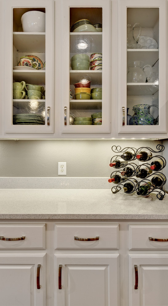 Mid-sized transitional u-shaped light wood floor eat-in kitchen photo in Austin with an undermount sink, white cabinets, quartz countertops, white backsplash, stone slab backsplash, stainless steel appliances, a peninsula and raised-panel cabinets