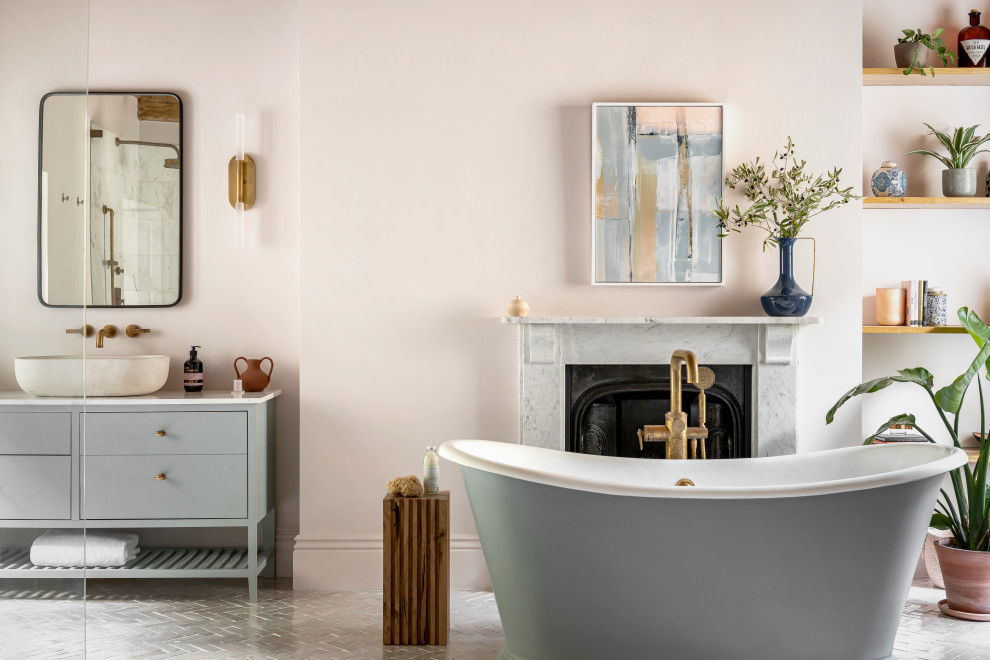 This is an example of a classic bathroom in Other with flat-panel cabinets, grey cabinets, a freestanding bath, pink walls, a vessel sink, grey floors, white worktops, a single sink and a freestanding vanity unit.