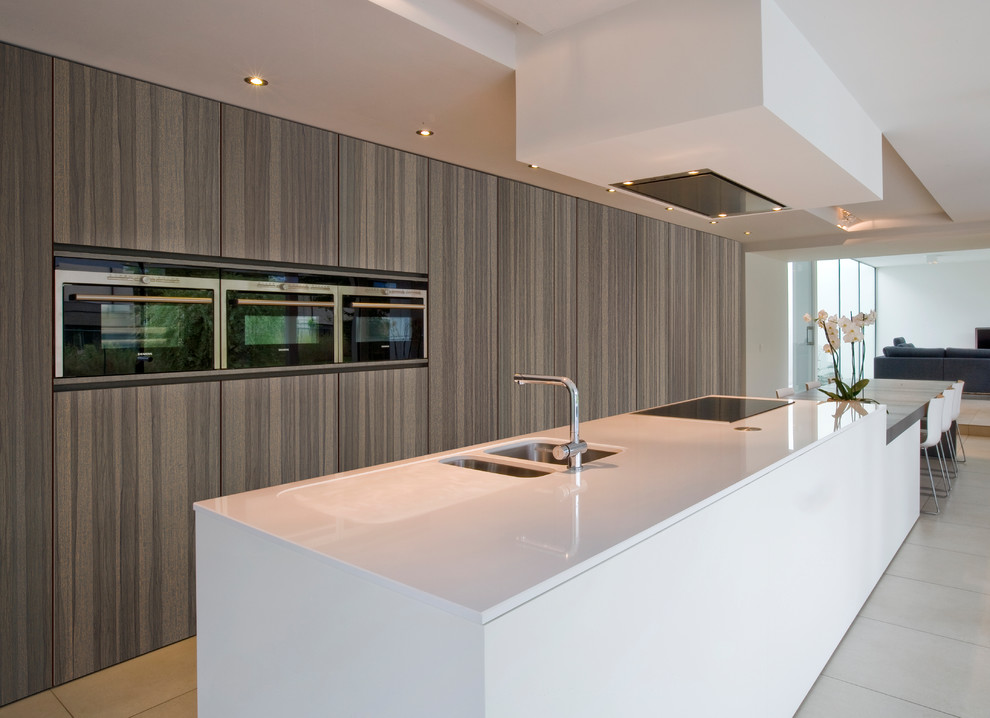 Huge minimalist single-wall porcelain tile and beige floor open concept kitchen photo in Minneapolis with an undermount sink, flat-panel cabinets, medium tone wood cabinets, quartz countertops, stainless steel appliances and an island