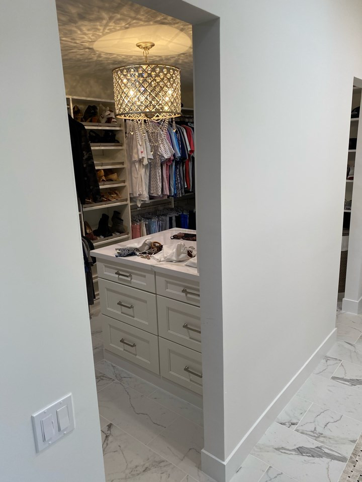 Example of a large cottage chic women's porcelain tile and white floor walk-in closet design in Phoenix with shaker cabinets and white cabinets