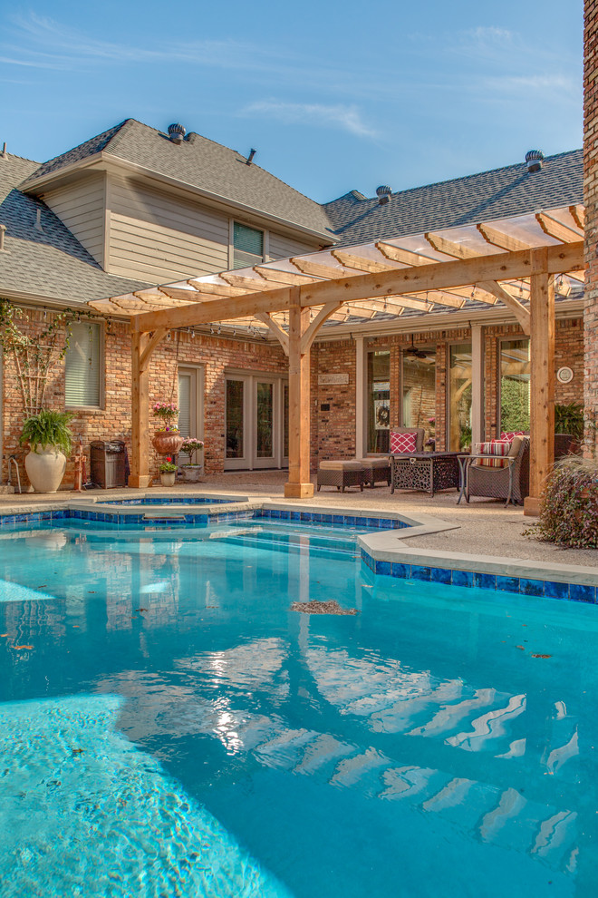 This is an example of a mid-sized traditional backyard patio in Dallas with a pergola.