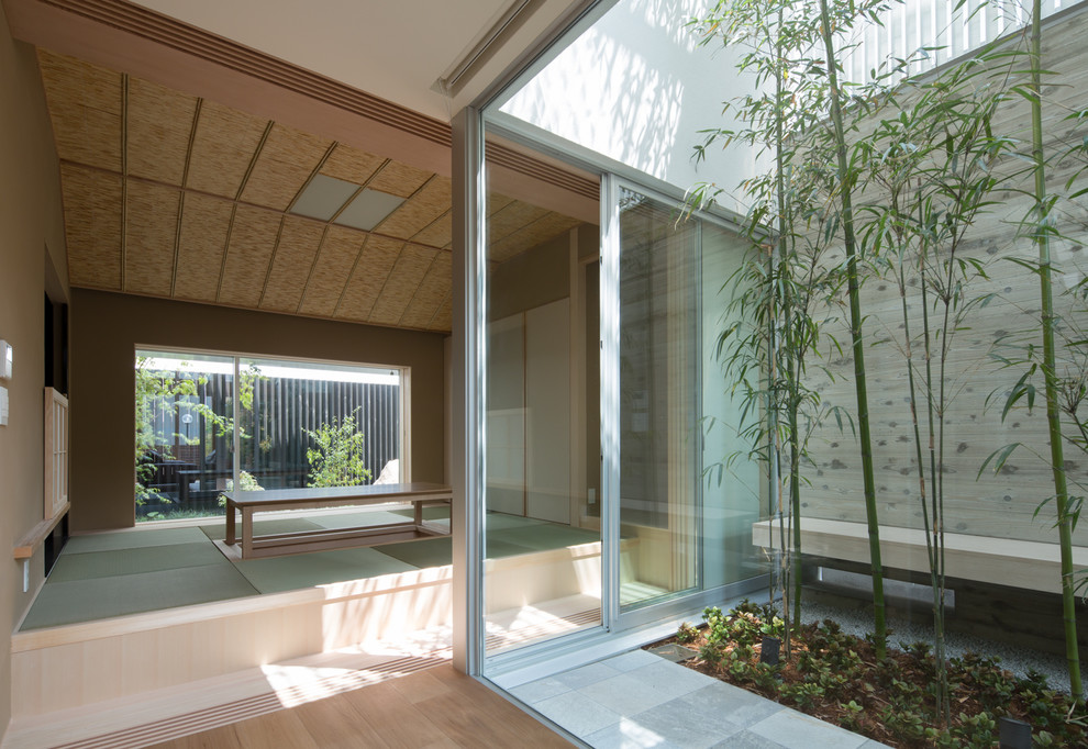 Asian enclosed family room in Osaka with beige walls, tatami floors and green floor.