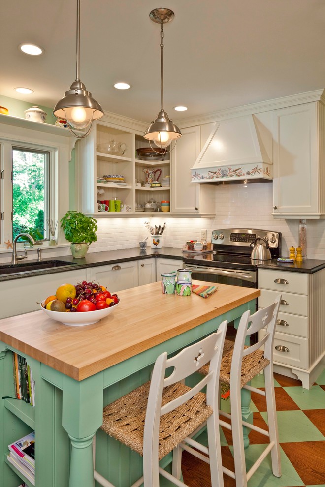 Inspiration for a beach style l-shaped kitchen in Portland Maine with an undermount sink, recessed-panel cabinets, white cabinets, white splashback, subway tile splashback, stainless steel appliances and with island.