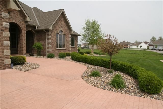 Photo of a traditional front yard driveway in Kansas City with brick pavers.
