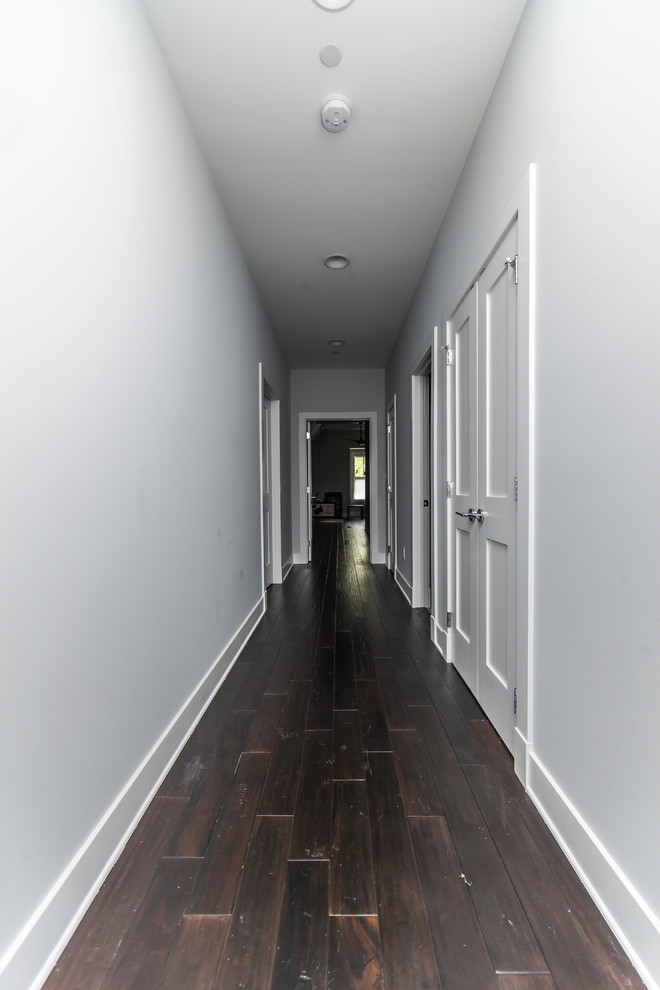 Photo of a large arts and crafts hallway in Baltimore with grey walls, dark hardwood floors and brown floor.