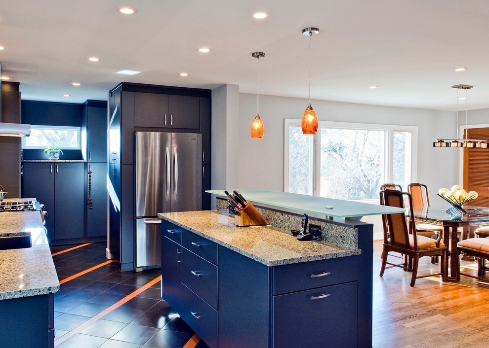 Example of a mid-sized transitional l-shaped medium tone wood floor and brown floor eat-in kitchen design in Orange County with an undermount sink, flat-panel cabinets, blue cabinets, granite countertops, beige backsplash, stainless steel appliances and an island
