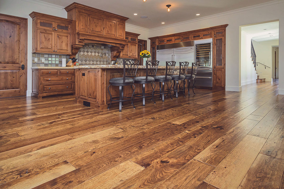This is an example of a traditional galley open plan kitchen in Atlanta with medium hardwood floors and with island.