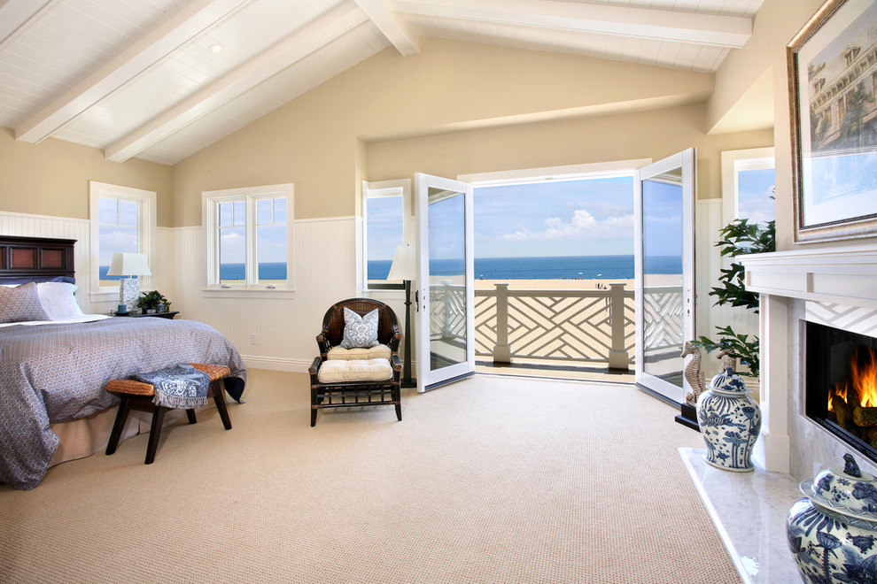 Beach style bedroom in Orange County with beige walls, carpet and a standard fireplace.