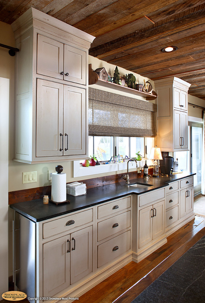 Inspiration for a country eat-in kitchen in Other with a farmhouse sink, beaded inset cabinets, green cabinets, limestone benchtops, yellow splashback and stainless steel appliances.
