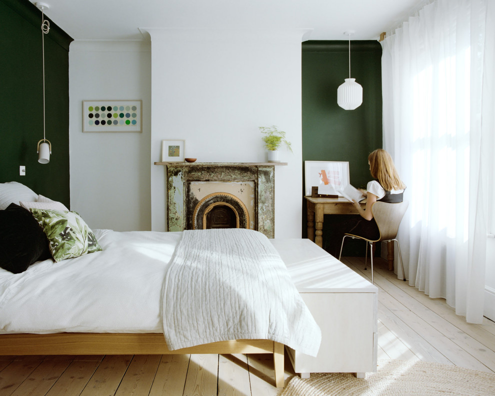 Mittelgroßes Modernes Hauptschlafzimmer mit weißer Wandfarbe, hellem Holzboden, Kamin und verputzter Kaminumrandung in London