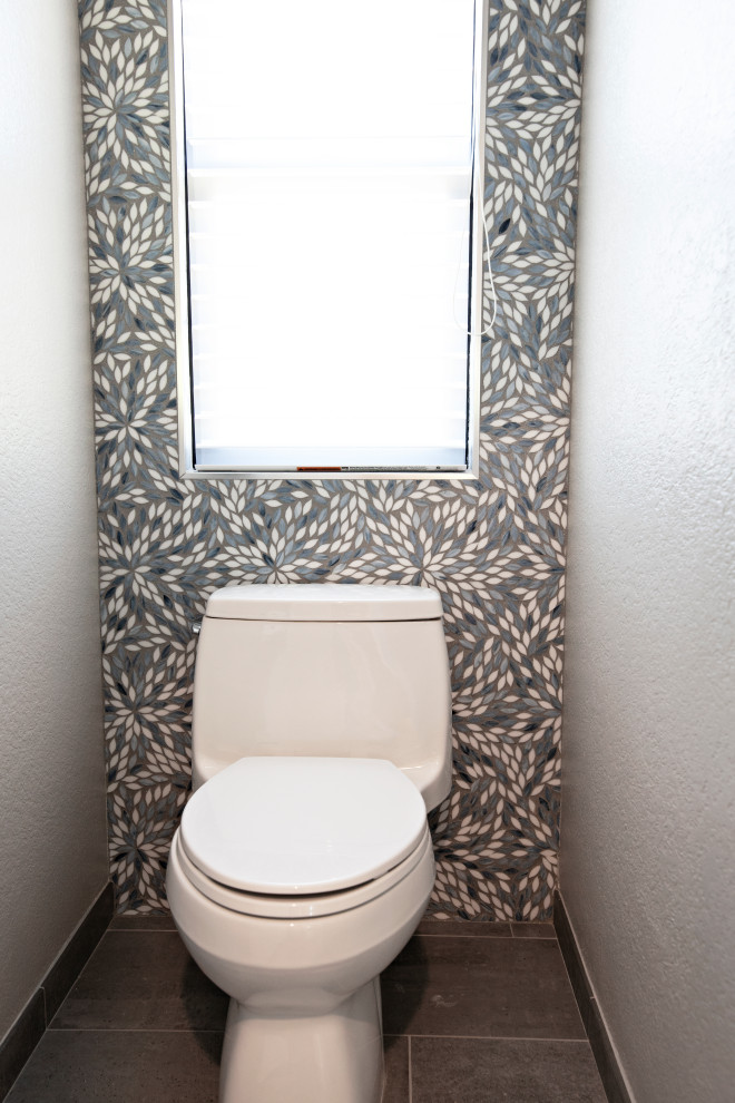Large beach style powder room in San Diego with flat-panel cabinets, light wood cabinets, blue tile, mosaic tile, grey walls, porcelain floors, an undermount sink, engineered quartz benchtops, grey floor, white benchtops and a floating vanity.