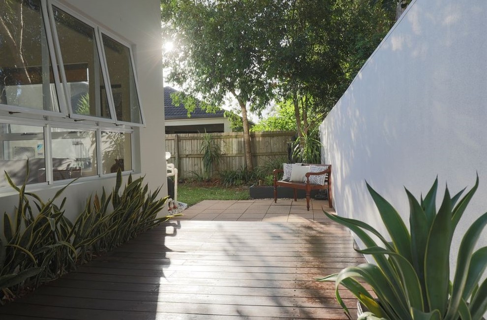 This is an example of a mid-sized traditional backyard patio in Sunshine Coast with tile and a roof extension.