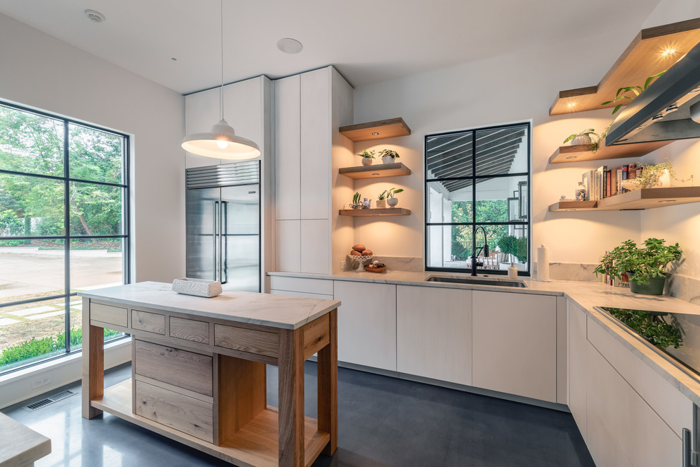 Kitchen pantry - concrete floor and gray floor kitchen pantry idea with an undermount sink, flat-panel cabinets, white cabinets, marble countertops, gray backsplash, marble backsplash, stainless steel appliances, an island and gray countertops