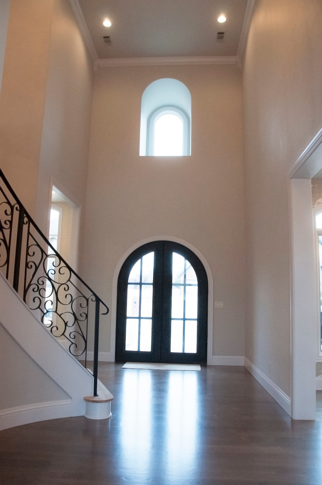 Inspiration for a large transitional dark wood floor foyer remodel with beige walls and a glass front door