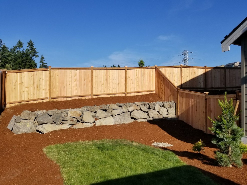 Photo of a mid-sized rustic backyard mulch formal garden in Seattle.