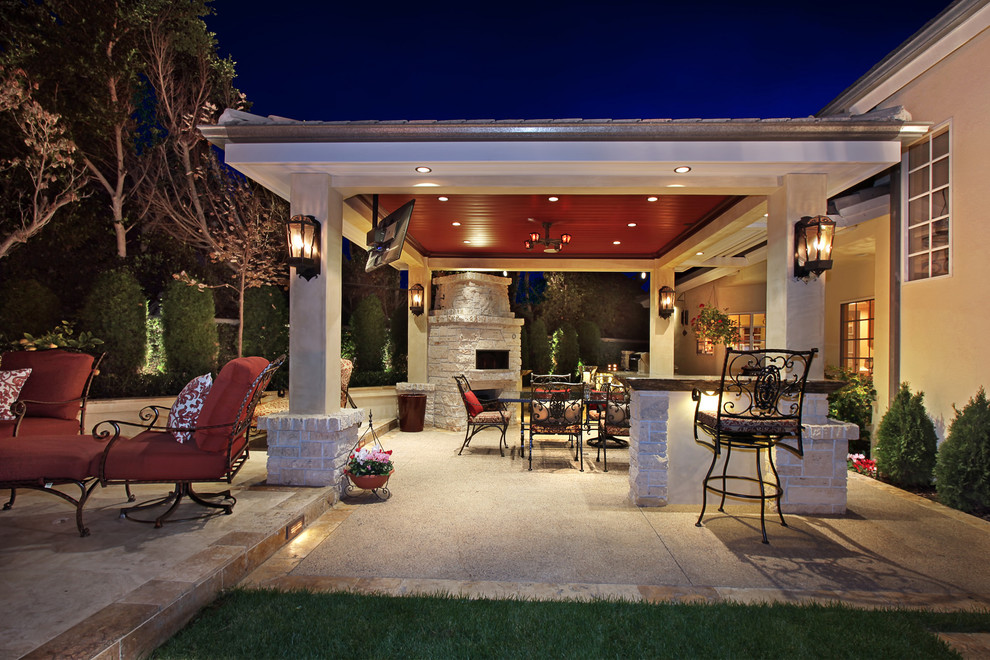 This is an example of a large tropical backyard patio in Orange County with an outdoor kitchen, concrete pavers and a gazebo/cabana.