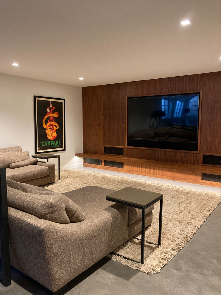 This is an example of a mid-sized midcentury open concept home theatre in Denver with white walls, concrete floors, a built-in media wall and grey floor.