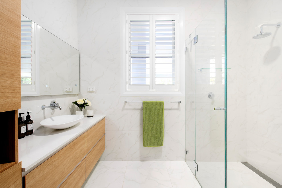 Photo of a contemporary 3/4 bathroom in Sydney with flat-panel cabinets, light wood cabinets, a curbless shower, white tile, white walls, a vessel sink, white floor, a hinged shower door and white benchtops.