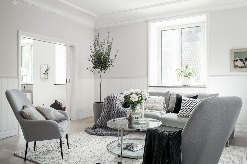 This is an example of a mid-sized scandinavian living room in Gothenburg with white walls, light hardwood floors and beige floor.