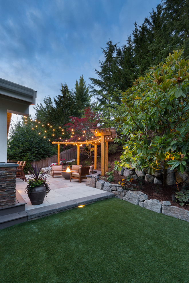 Inspiration for a large transitional backyard patio in Seattle with a fire feature and concrete pavers.