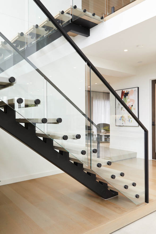 Inspiration pour un grand escalier sans contremarche design en U avec des marches en bois et un garde-corps en métal.