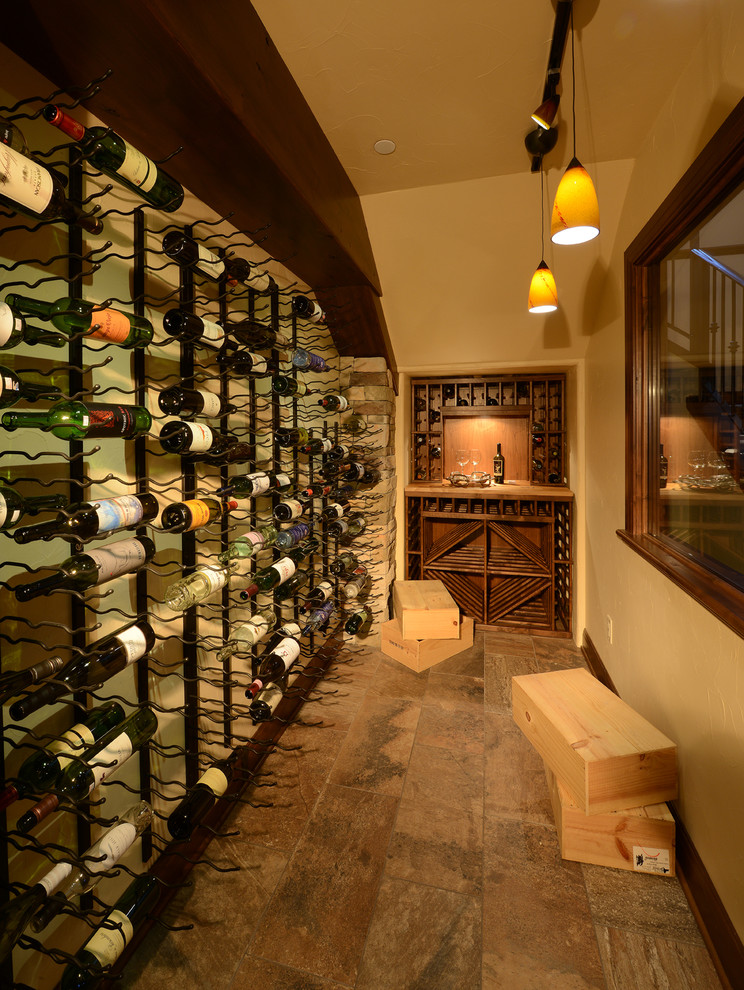 Inspiration for a mediterranean wine cellar in Denver with brown floor.